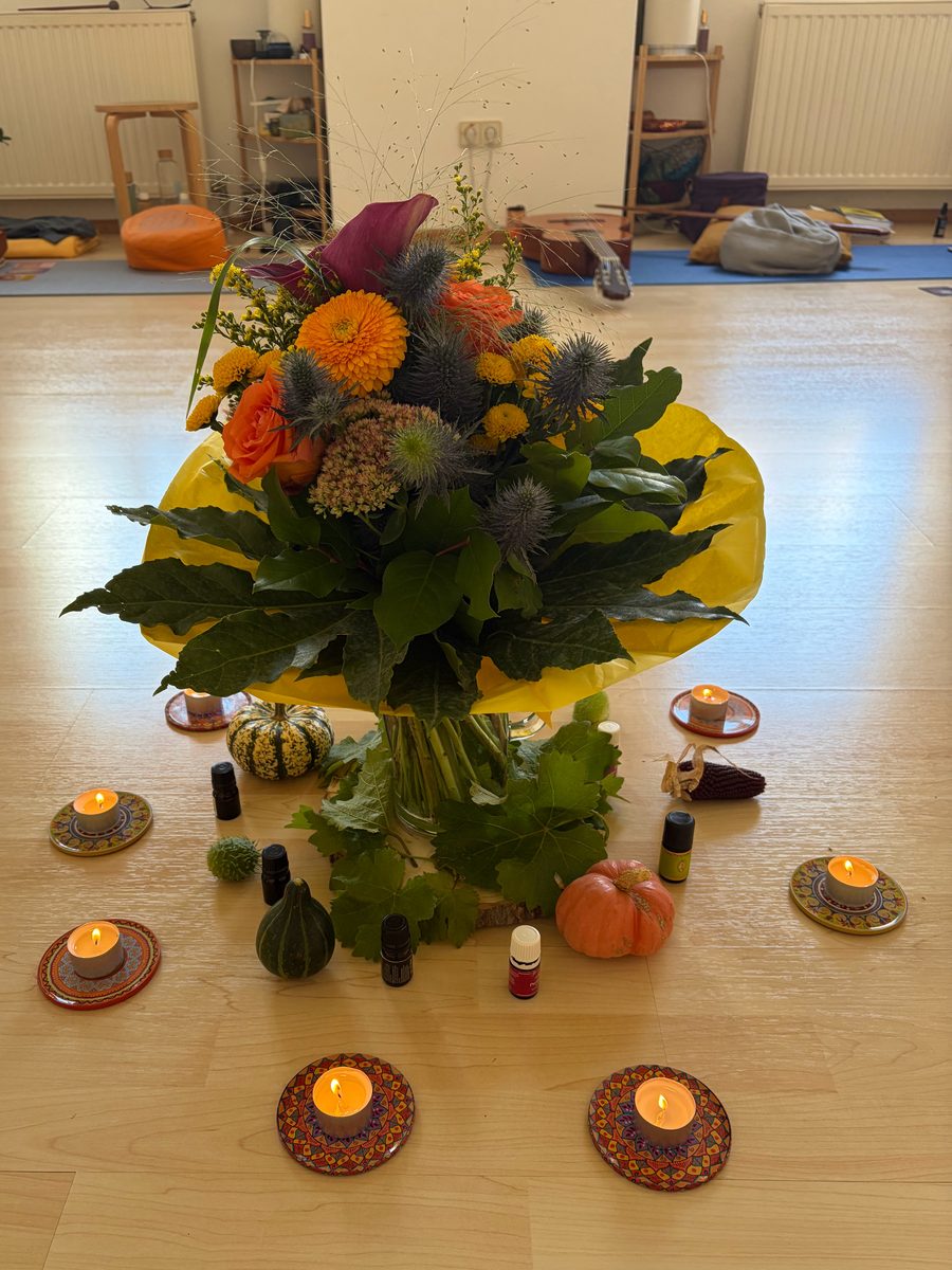 Blumenmitte mit Kerzen und ätherischen Ölen im Seminarraum